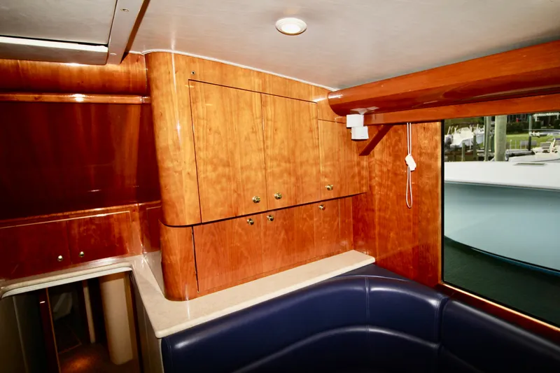 Let's Ride Yacht Photos Pics Interior of 2004 Sculley Custom Carolina 58' Sportfish with wood cabinetry and blue seating.