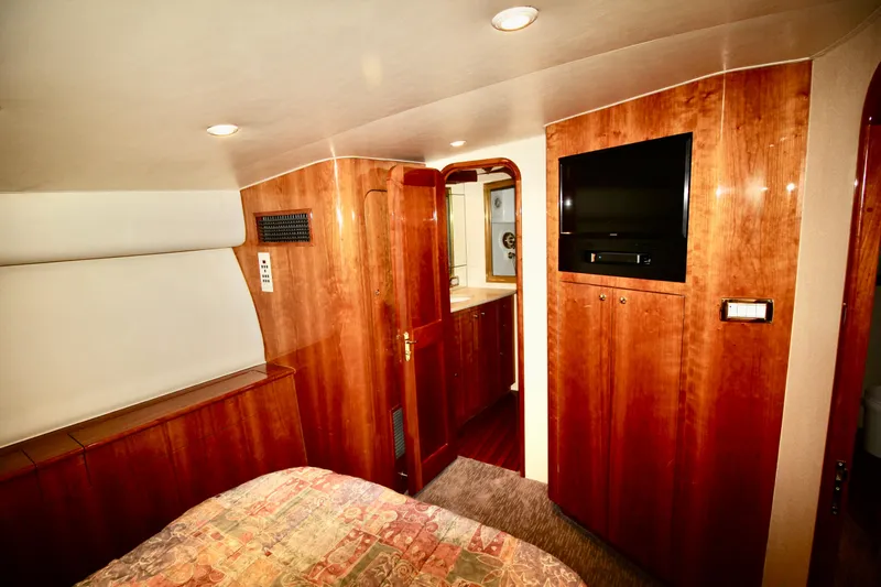 Let's Ride Yacht Photos Pics Luxurious cabin interior of 2004 Sculley Custom Carolina 58' Sportfish with wood paneling and TV.