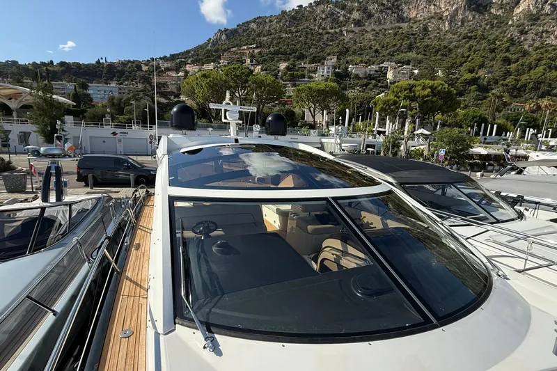 Helios Yacht Photos Pics Sunseeker Predator 60 yacht, 2010 model, docked in a scenic marina setting.