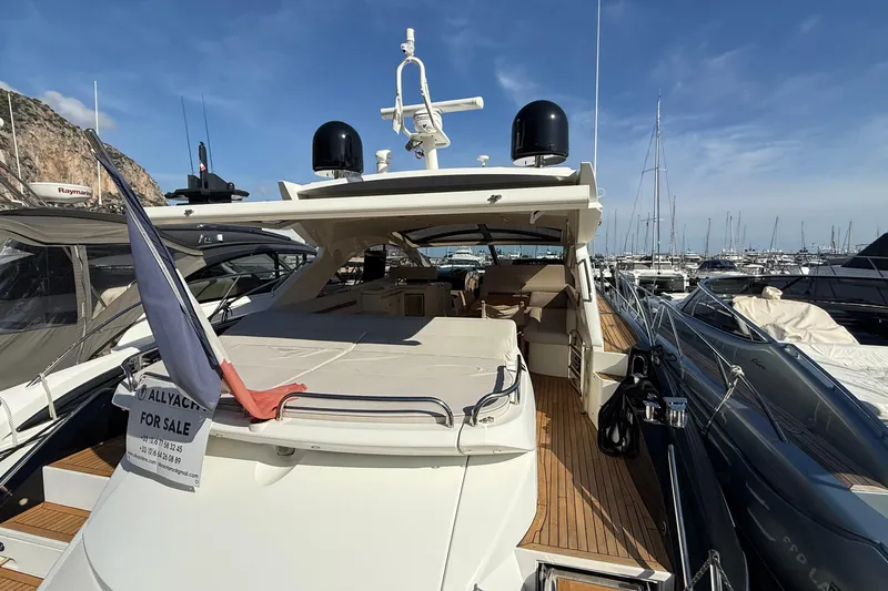 Helios Yacht Photos Pics 2010 Sunseeker Predator 60 yacht for sale, docked in marina under clear blue sky.