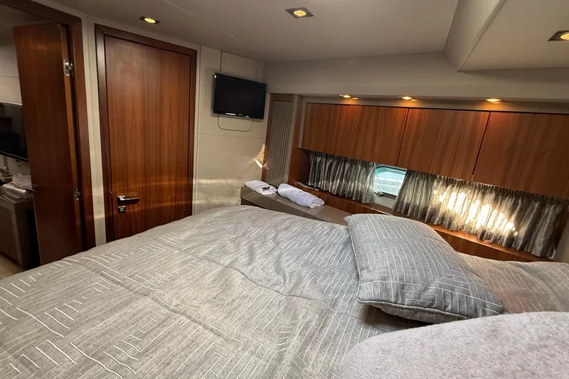 Helios Yacht Photos Pics Luxurious cabin interior of 2010 Sunseeker Predator 60 yacht with cozy bedding and wooden accents.