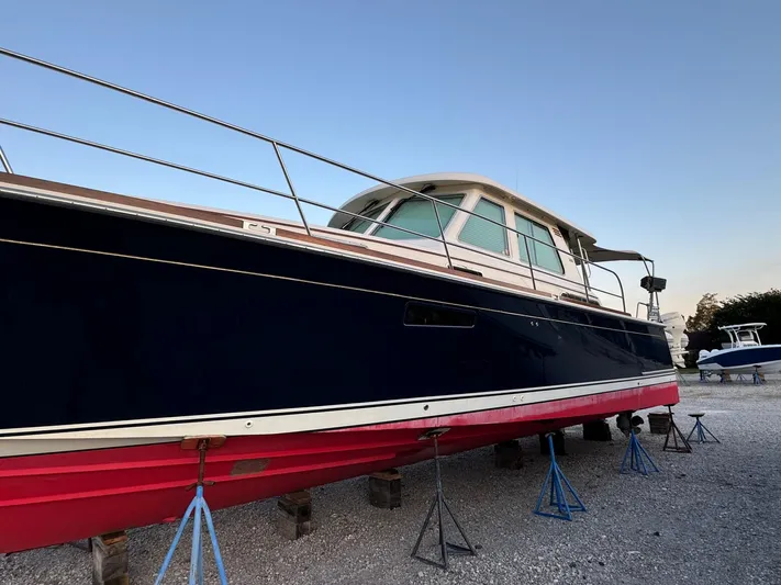  Yacht Photos Pics 2012 Sabre 48 Salon Express yacht on stands, blue hull, red bottom, outdoor setting.