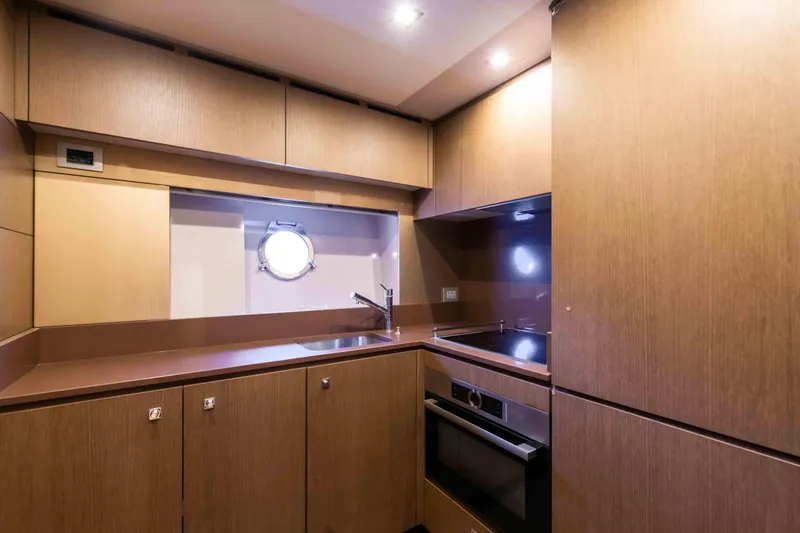  Yacht Photos Pics Luxurious kitchen interior of 2016 Ferretti Yachts 870 with modern appliances and wood finish.