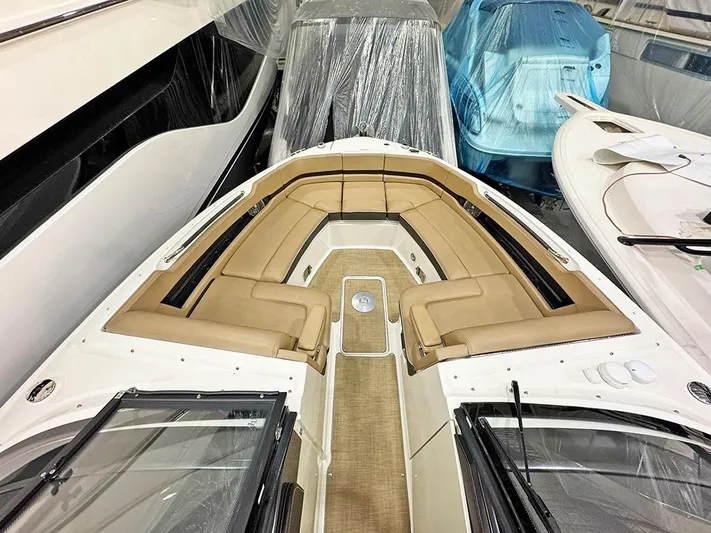  Yacht Photos Pics 2017 Sea Ray SLX 310 boat with tan seating, docked indoors among other boats.
