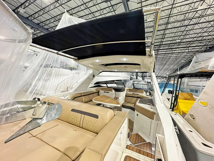  Yacht Photos Pics 2017 Sea Ray SLX 310 boat interior with tan seating and black canopy in a showroom.