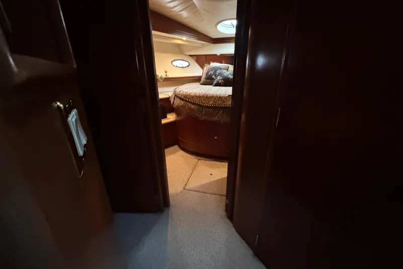 Moonstruck Yacht Photos Pics Interior view of 1998 Carver 530 Voyager Pilothouse bedroom with cozy bed and wooden finish.
