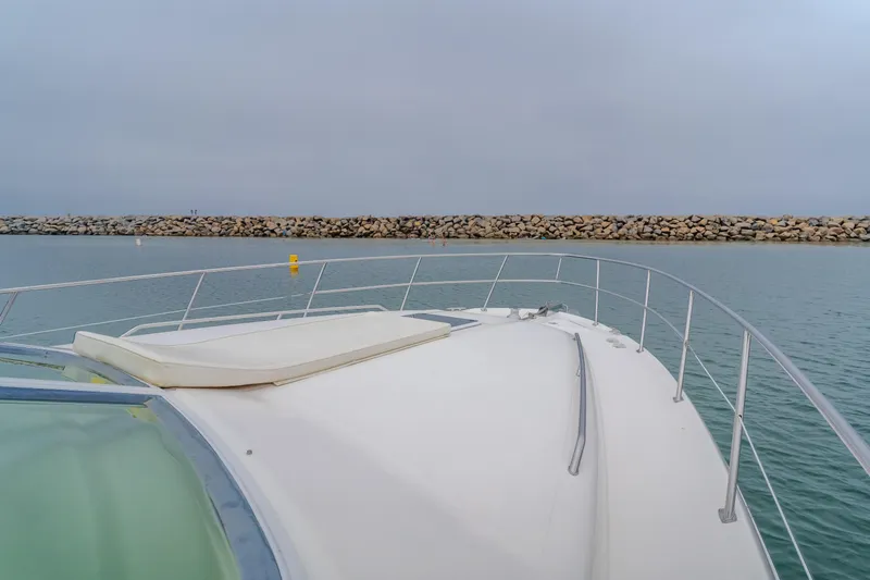Waterfront Property Yacht Photos Pics Bow view of a 2000 Sea Ray 400 Sedan Bridge yacht in calm waters.