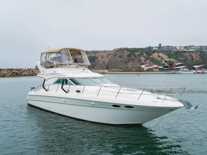 Waterfront Property Yacht Photos Pics 2000 Sea Ray 400 Sedan Bridge yacht cruising in a coastal harbor.