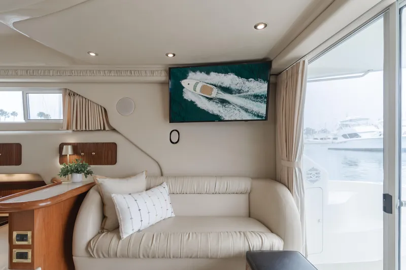 Waterfront Property Yacht Photos Pics Interior of 2000 Sea Ray 400 Sedan Bridge yacht with sofa and wall-mounted TV.