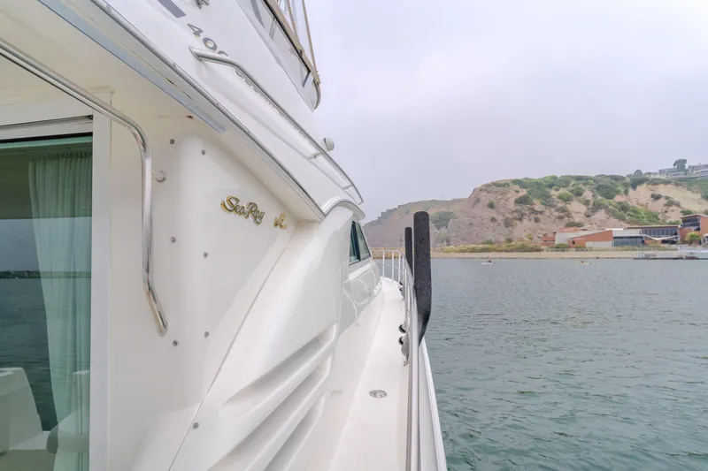 Waterfront Property Yacht Photos Pics Side view of a 2000 Sea Ray 400 Sedan Bridge yacht docked by the shore.