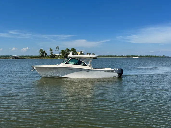  Yacht Photos Pics 2021 Grady-White Freedom 375 boat on calm water under clear blue sky.