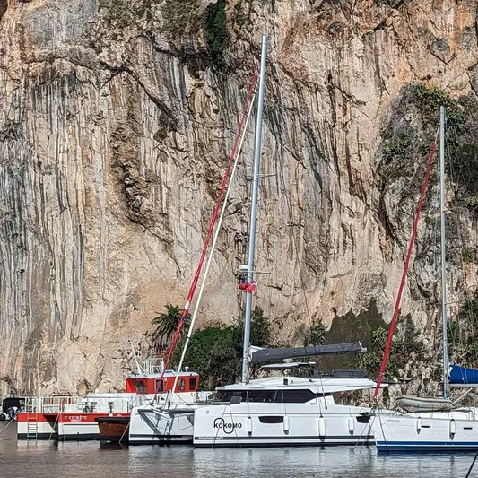  Yacht Photos Pics Fountaine Pajot Elba 45 catamaran docked near rocky cliff, 2022 model.