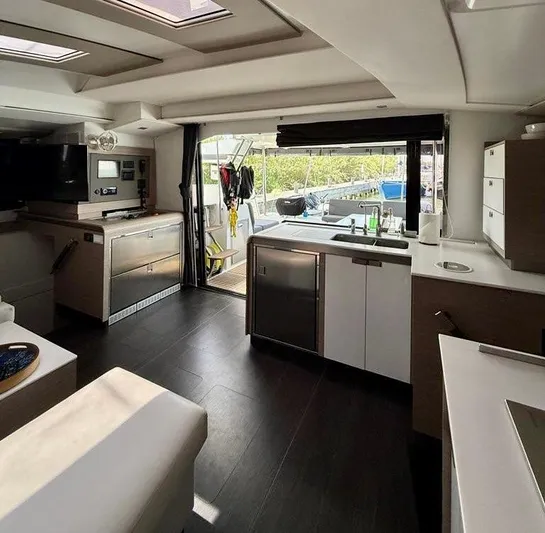  Yacht Photos Pics Modern interior of 2022 Fountaine Pajot Elba 45 catamaran with open kitchen and outdoor view.