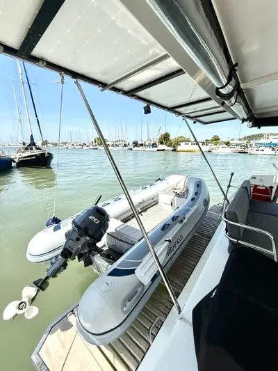  Yacht Photos Pics 2022 Fountaine Pajot Elba 45 catamaran with inflatable dinghy, docked in a marina.