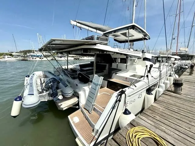  Yacht Photos Pics 2022 Fountaine Pajot Elba 45 catamaran docked at marina, featuring modern design and spacious deck.
