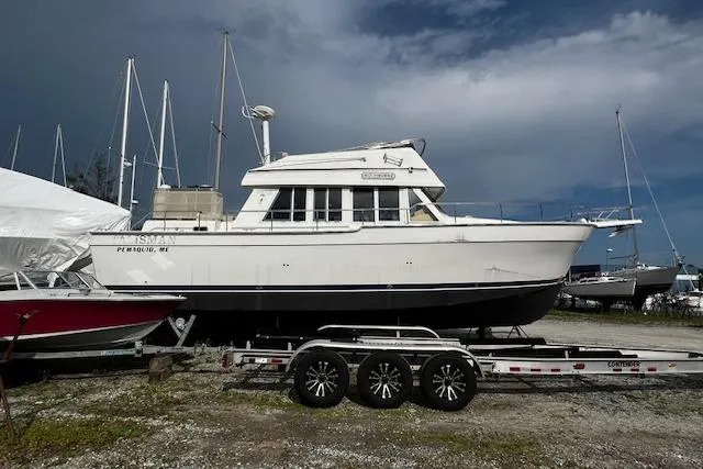 Talisman Yacht Photos Pics 2003 Mainship 430 Aft Cabin Trawler on trailer, parked in a boatyard.