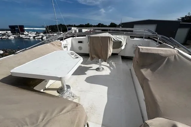 Talisman Yacht Photos Pics 2003 Mainship 430 Aft Cabin Trawler deck with covered seating and table, docked at marina.