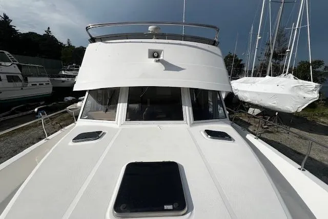 Talisman Yacht Photos Pics 2003 Mainship 430 Aft Cabin Trawler docked, showcasing its sleek design and spacious deck.