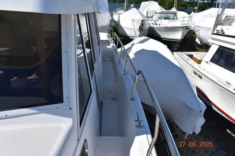 Talisman Yacht Photos Pics 2003 Mainship 430 Aft Cabin Trawler docked, surrounded by covered boats.