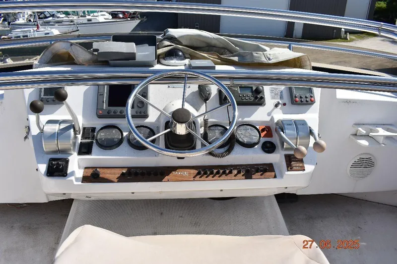 Talisman Yacht Photos Pics 2003 Mainship 430 Aft Cabin Trawler helm with steering wheel and navigation controls.