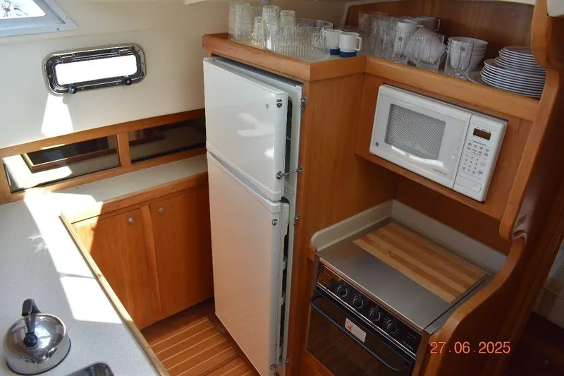 Talisman Yacht Photos Pics 2003 Mainship 430 Aft Cabin Trawler kitchen with fridge, microwave, and stove.