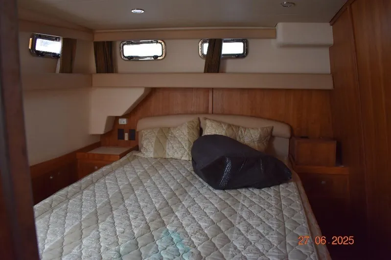 Talisman Yacht Photos Pics 2003 Mainship 430 Aft Cabin Trawler bedroom with cozy bed and wooden interior.