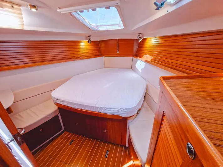  Yacht Photos Pics Cozy cabin interior of 2011 Catalina 445 sailboat with wood paneling and a comfortable bed.