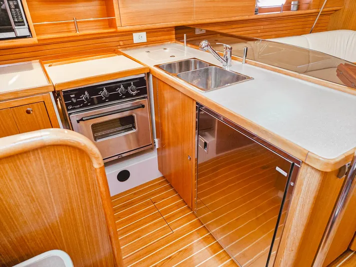  Yacht Photos Pics 2011 Catalina 445 yacht kitchen with stove, sink, and wooden cabinetry.