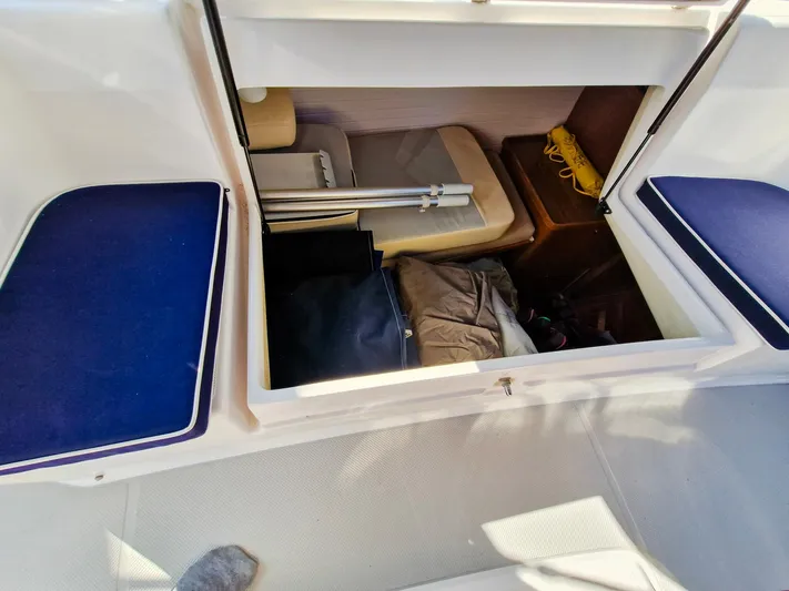  Yacht Photos Pics Storage compartment in a 2011 Catalina 445 sailboat, featuring blue cushions and various stored items.