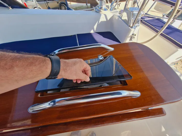  Yacht Photos Pics Hand opening hatch on 2011 Catalina 445 sailboat deck with polished wood and metal handles.