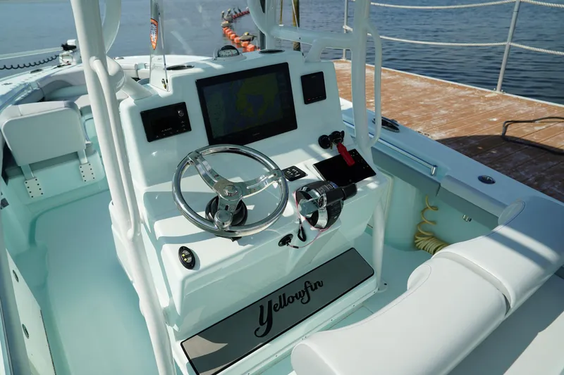  Yacht Photos Pics 2020 Yellowfin 26 Hybrid boat console with steering wheel and navigation screen.