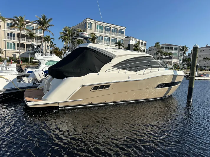 Nauti-lin Yacht Photos Pics 2016 Carver C37 Coupe yacht docked in marina, surrounded by luxury buildings.
