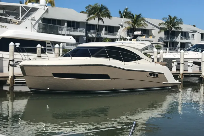 Nauti-lin Yacht Photos Pics 2016 Carver C37 Coupe yacht docked at marina with palm trees and buildings.