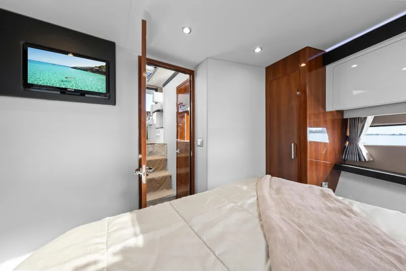 Nauti-lin Yacht Photos Pics Interior of 2016 Carver C37 Coupe yacht bedroom with TV and wooden cabinetry.