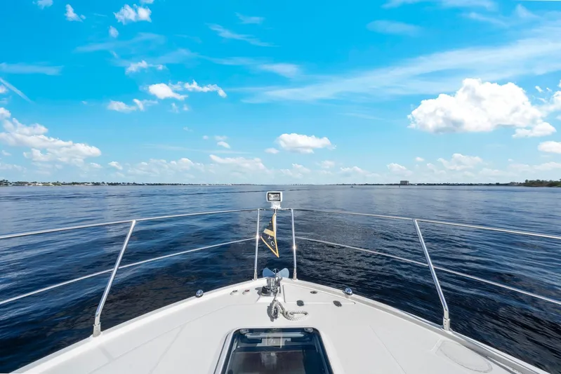 Nauti-lin Yacht Photos Pics Bow view from 2016 Carver C37 Coupe yacht on open water under blue sky.
