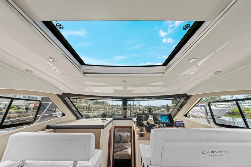 Nauti-lin Yacht Photos Pics Interior view of 2016 Carver C37 Coupe yacht with panoramic windows and modern helm.