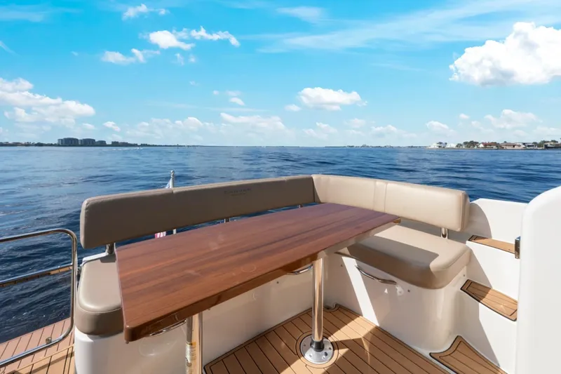 Nauti-lin Yacht Photos Pics 2016 Carver C37 Coupe yacht deck with seating and table, overlooking serene water.