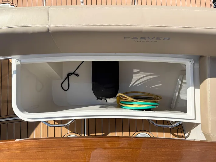 Nauti-lin Yacht Photos Pics Storage compartment on 2016 Carver C37 Coupe yacht with coiled rope and black bag.