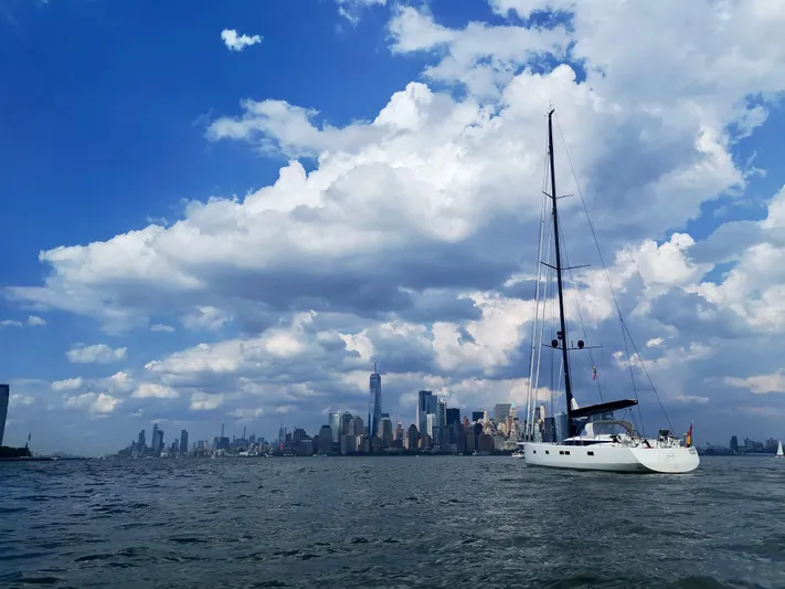 Juul Yacht Photos Pics Sailboat CNB 66 (2019) on water with city skyline and cloudy sky background.