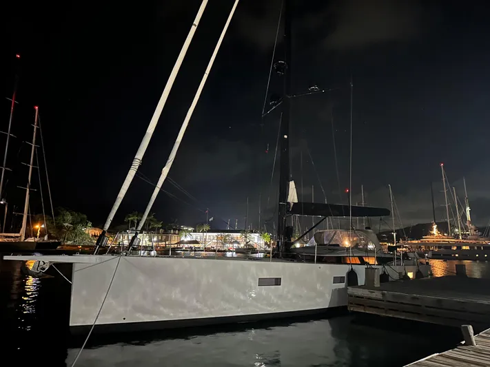 Juul Yacht Photos Pics Luxurious 2019 CNB 66 yacht docked at night, illuminated by harbor lights.