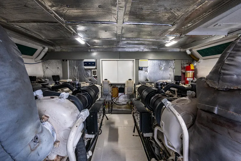  Yacht Photos Pics Engine room of a 2000 Pershing 65 Limited yacht, showcasing dual engines and metallic insulation.