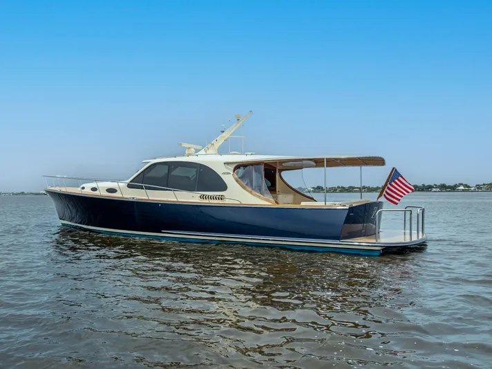 Zephyr Yacht Photos Pics 2018 Palm Beach Motor Yachts PB55 on calm water, displaying sleek design and American flag.
