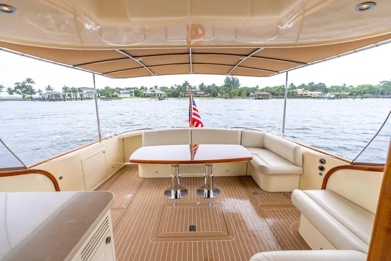 Zephyr Yacht Photos Pics 2018 Palm Beach Motor Yachts PB55 aft deck with seating, table, and water view.