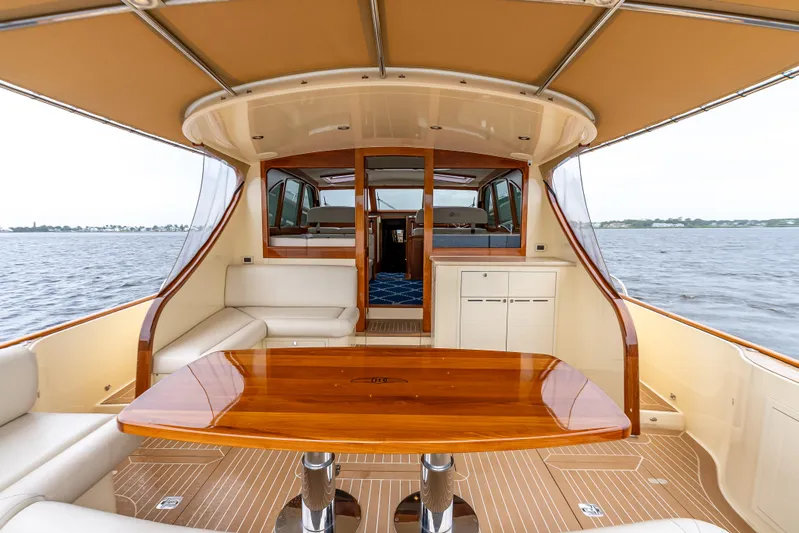 Zephyr Yacht Photos Pics 2018 Palm Beach Motor Yachts PB55 interior with elegant wood table and seating, overlooking the water.