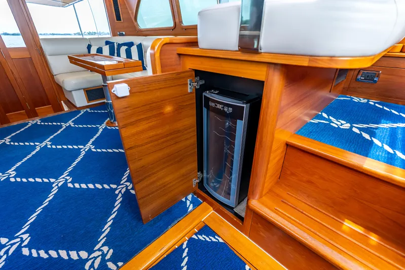Zephyr Yacht Photos Pics Luxurious interior of 2018 Palm Beach Motor Yachts PB55 with wooden cabinetry and mini fridge.