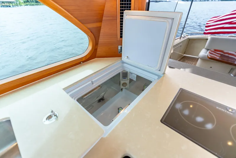 Zephyr Yacht Photos Pics 2018 Palm Beach Motor Yachts PB55 interior with open storage compartment and scenic water view.