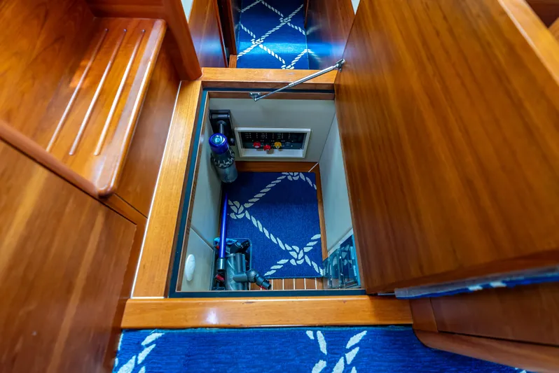Zephyr Yacht Photos Pics 2018 Palm Beach Motor Yachts PB55 interior storage compartment with wooden finish and nautical-themed carpet.