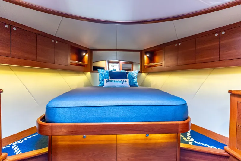 Zephyr Yacht Photos Pics Luxurious cabin interior of 2018 Palm Beach Motor Yachts PB55 with blue bedding and wooden accents.