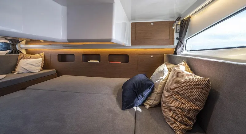 In Stock Yacht Photos Pics Interior of 2026 Beneteau Antares 11, featuring cozy seating and decorative pillows.