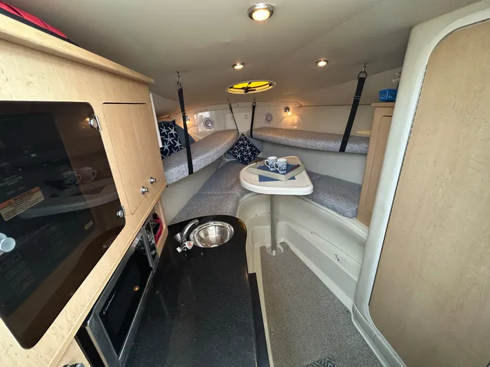 Good Sport Yacht Photos Pics 2011 Hydra-Sports 3000 VX cabin interior with kitchenette, seating, and cozy sleeping area.